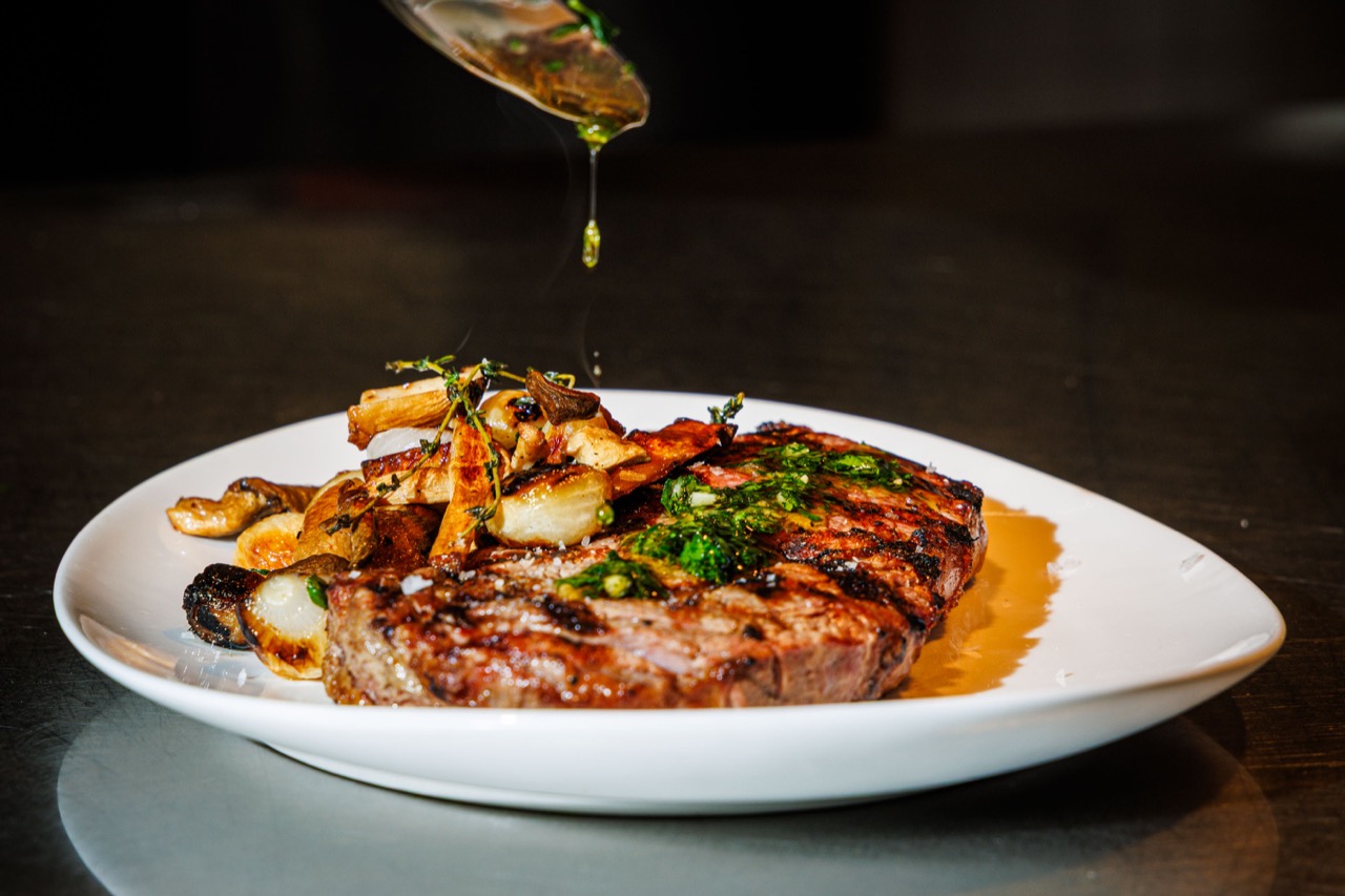 Chef plating steak at The Alexander kitchen